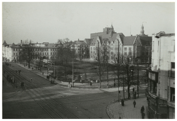 Foto des Adolf-Hitler-Platzes (heute Graf-Adolf-Platz) nach einem Luftangriff. Im Hintergrund ist das Telegrafenamt, in der Mitte die Oberpostdirektion und ganz rechts die Ruine des Café Wien zu erkennen, 25.8.1942